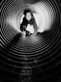 Portrait of girl crawling in pipe