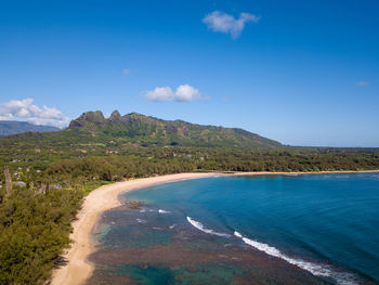 Scenic view of sea and mountains against blue sky