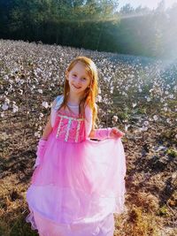 Portrait of smiling girl standing on field