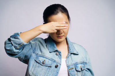 Portrait of a young woman against white background