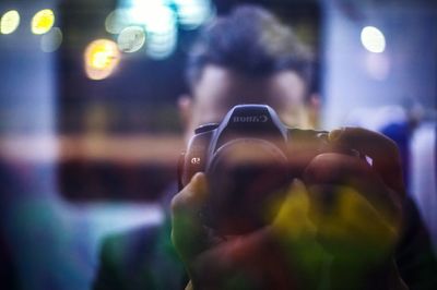 Close-up of woman photographing illuminated smart phone