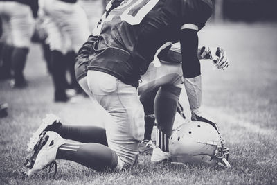 Low section of players kneeling on grassy field