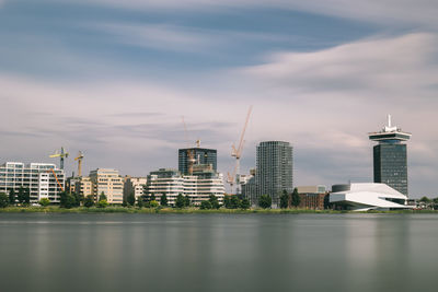 Modern buildings in city against sky amsterdam skyline eye museum long exposure