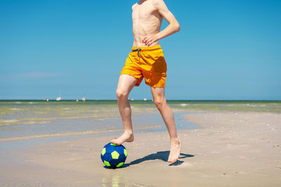 Full length of man playing with ball on beach