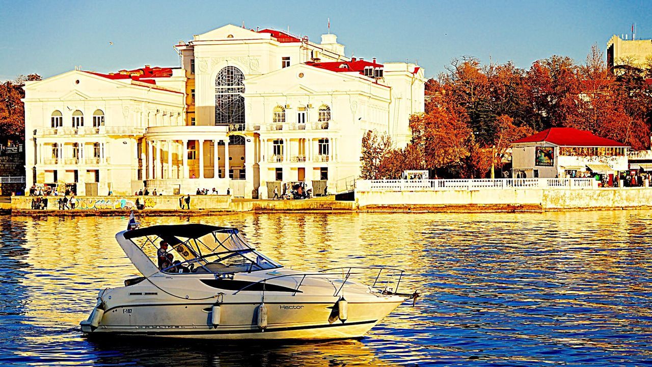 building exterior, architecture, built structure, water, residential building, waterfront, residential structure, house, canal, building, tree, city, clear sky, reflection, day, outdoors, incidental people, sunlight, sky, bare tree