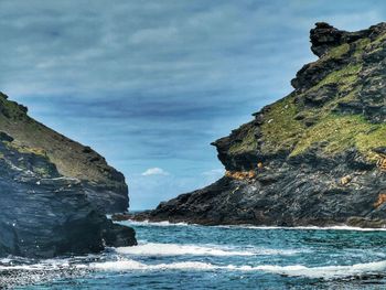 Rock formations by sea against sky