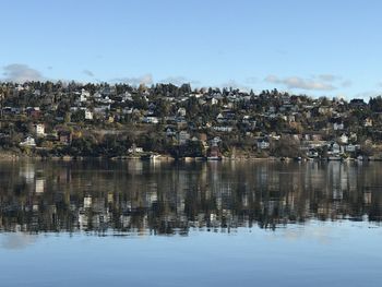 Townscape by river against sky in town