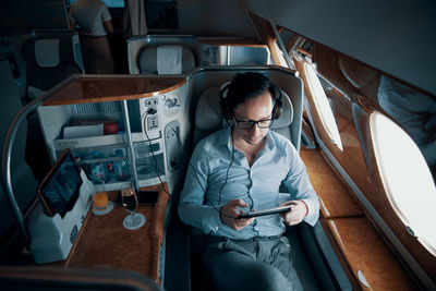 Man using mobile phone while sitting in bus