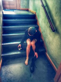 High angle view of woman sitting on staircase