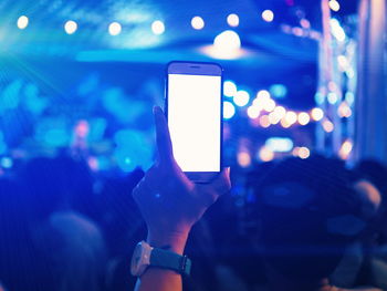 Close-up of hand holding smart phone at night