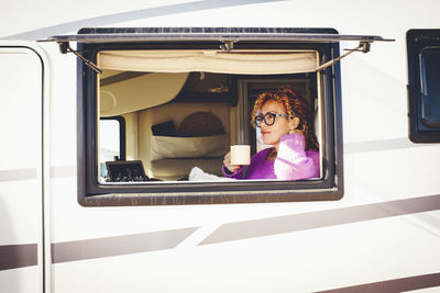 Woman having coffee in camper van