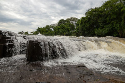 Scenic view of waterfall against sky