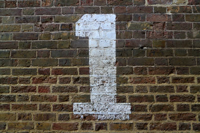 Close-up of arrow symbol on brick wall