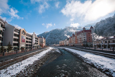 Panoramic view of railroad tracks amidst buildings in city against sky