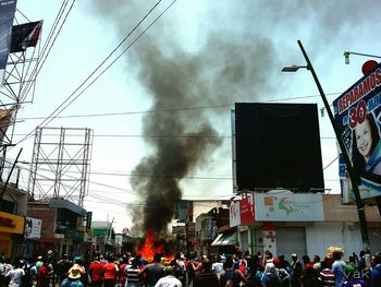 People in city against cloudy sky
