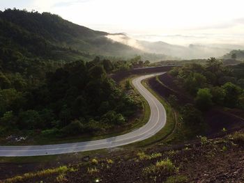 Scenic view of road by mountains against sky