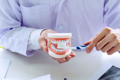 Midsection of man holding coffee cup