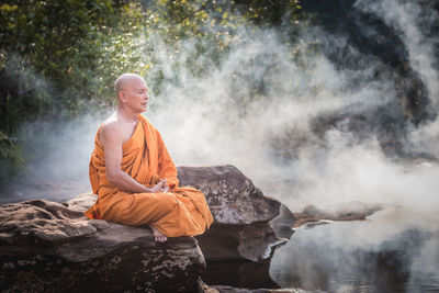 Man meditating on rocks