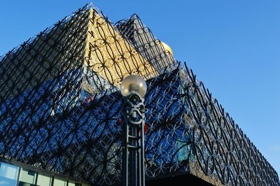 Low angle view of modern building against blue sky