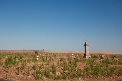 Western pioneer cemetery in arid prairie  landscape under clear blue summer sky.