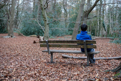 Boy sitting on bench in the woods of wimbledon common