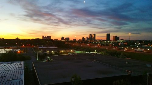 Cityscape against cloudy sky at sunset