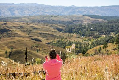 Rear view of woman standing on landscape