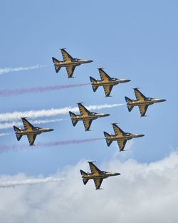 Low angle view of airshow against sky