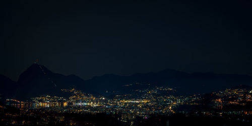 High angle view of illuminated city against sky at night