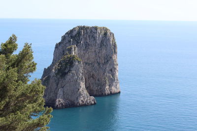 Rock formations in sea against clear sky