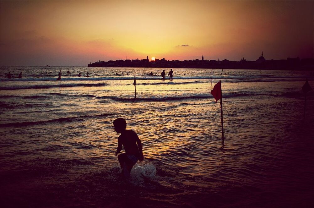 sunset, sea, beach, water, orange color, silhouette, shore, horizon over water, leisure activity, scenics, lifestyles, men, beauty in nature, tranquil scene, sky, sand, full length, tranquility, idyllic