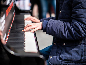 Midsection of man playing piano