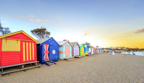 Beach huts against sky during sunset