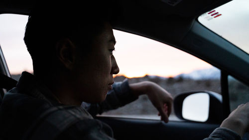 Portrait of man seen through car windshield