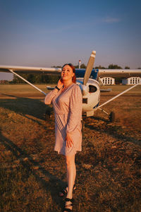 Image of a beautiful girl on the background of an airplane on a warm summer day at the airport