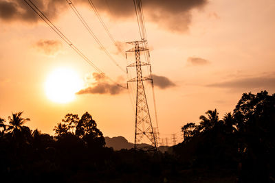 Low angle view of silhouette electricity pylon against sky during sunset
