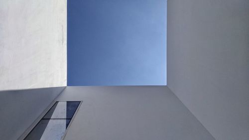 Low angle view of building against blue wall