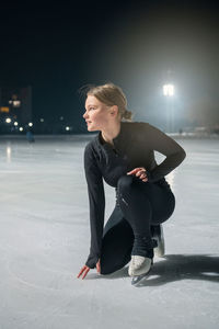 Side view of man sitting on snow