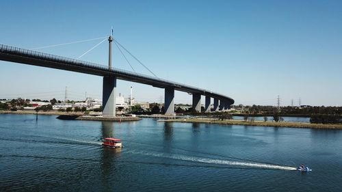 Bridge over river against clear blue sky