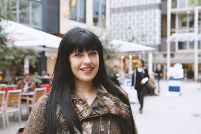 Portrait of smiling young woman in city