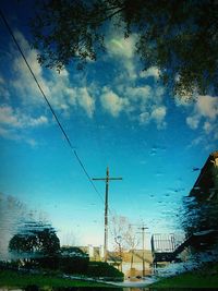 Power lines against cloudy sky