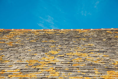 Close-up of yellow wall against sky