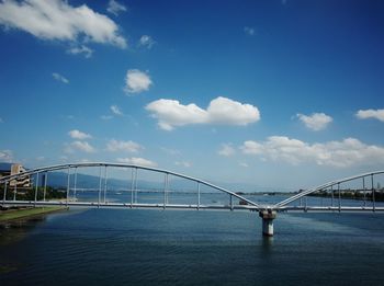 Bridge over sea against blue sky