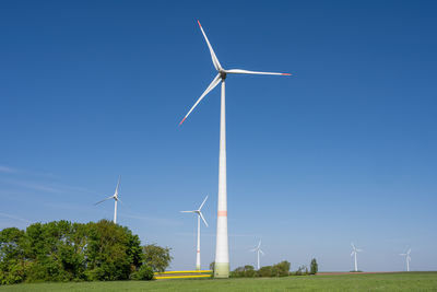 Low angle view of windmill against clear blue sky