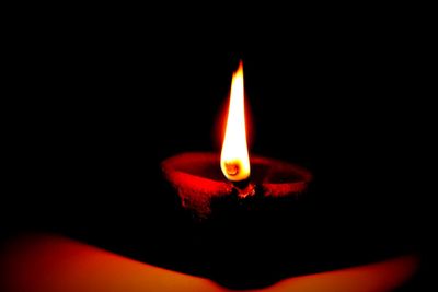 Lit candle in dark room