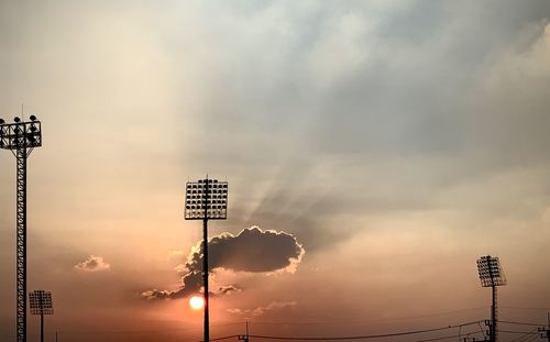 Low angle view of road sign against sky during sunset