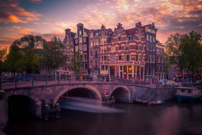 Bridge over river against sky during sunset