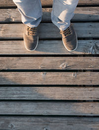 Low section of man standing on wood