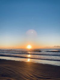 Scenic view of sea against clear sky during sunset