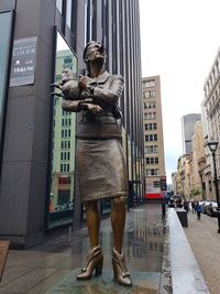 Statues on street amidst buildings in city